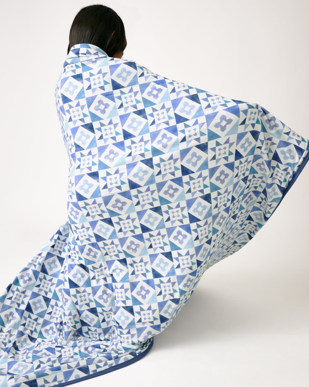 Child in motion wrapped in the Patchwork Indigo Large Cloud Blanket® 