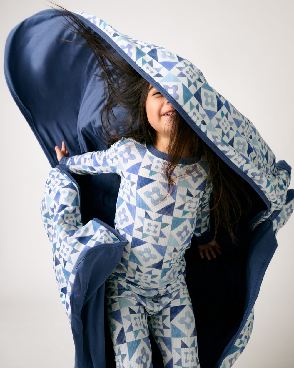 Girl in motion holding the Patchwork Indigo Large Cloud Blanket®