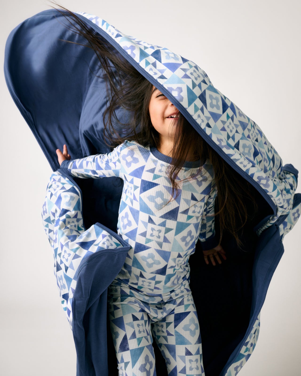 Girl in motion holding the Patchwork Indigo Large Cloud Blanket®