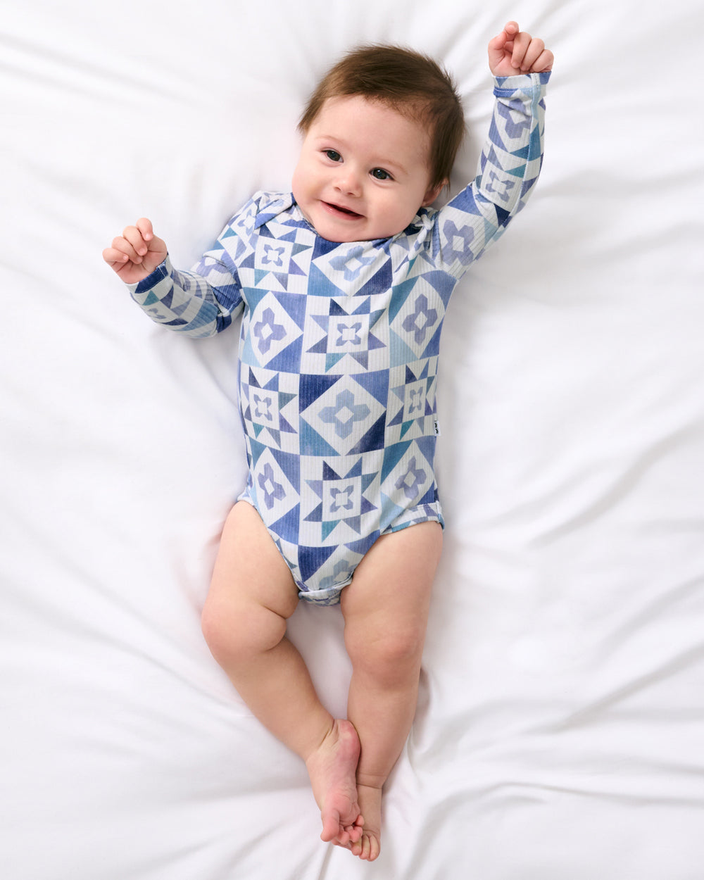 Aerial view of baby wearing the Patchwork Indigo Ribbed Bodysuit