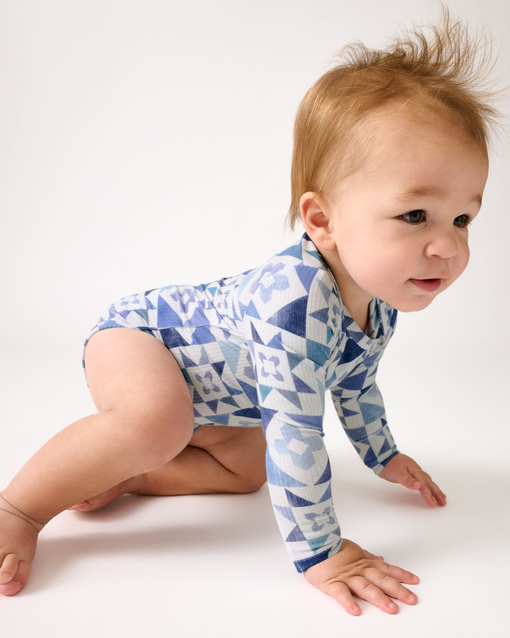 Crawling baby wearing the Patchwork Indigo Ribbed Bodysuit