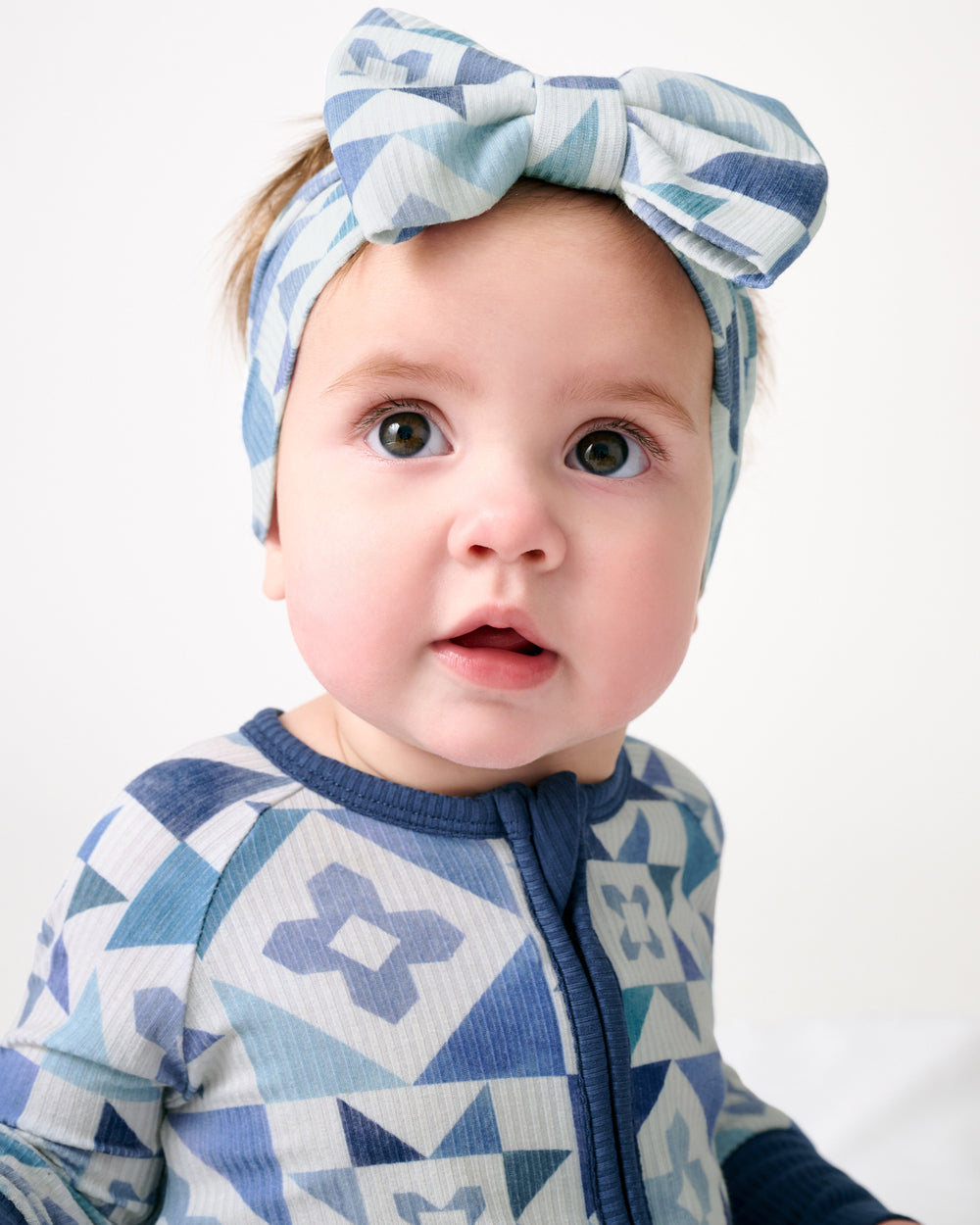 Close up of newborn wearing the Patchwork Indigo Ribbed Luxe Bow Headband