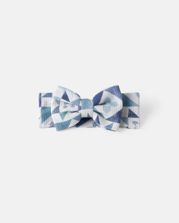 Flat lay of the Patchwork Indigo Ribbed Luxe Bow Headband