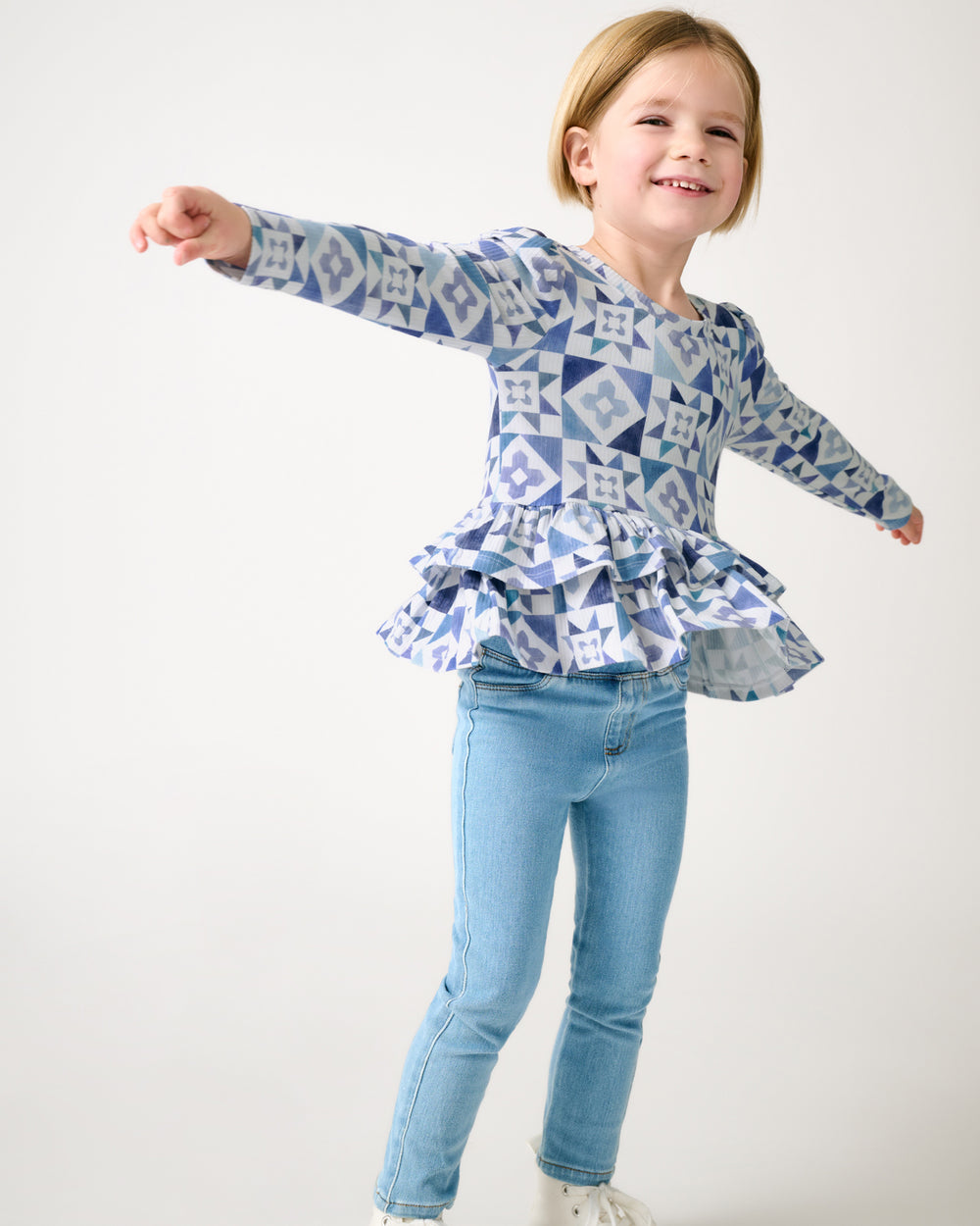 Girl wearing the Patchwork Indigo Ribbed Peplum Top with denim pants