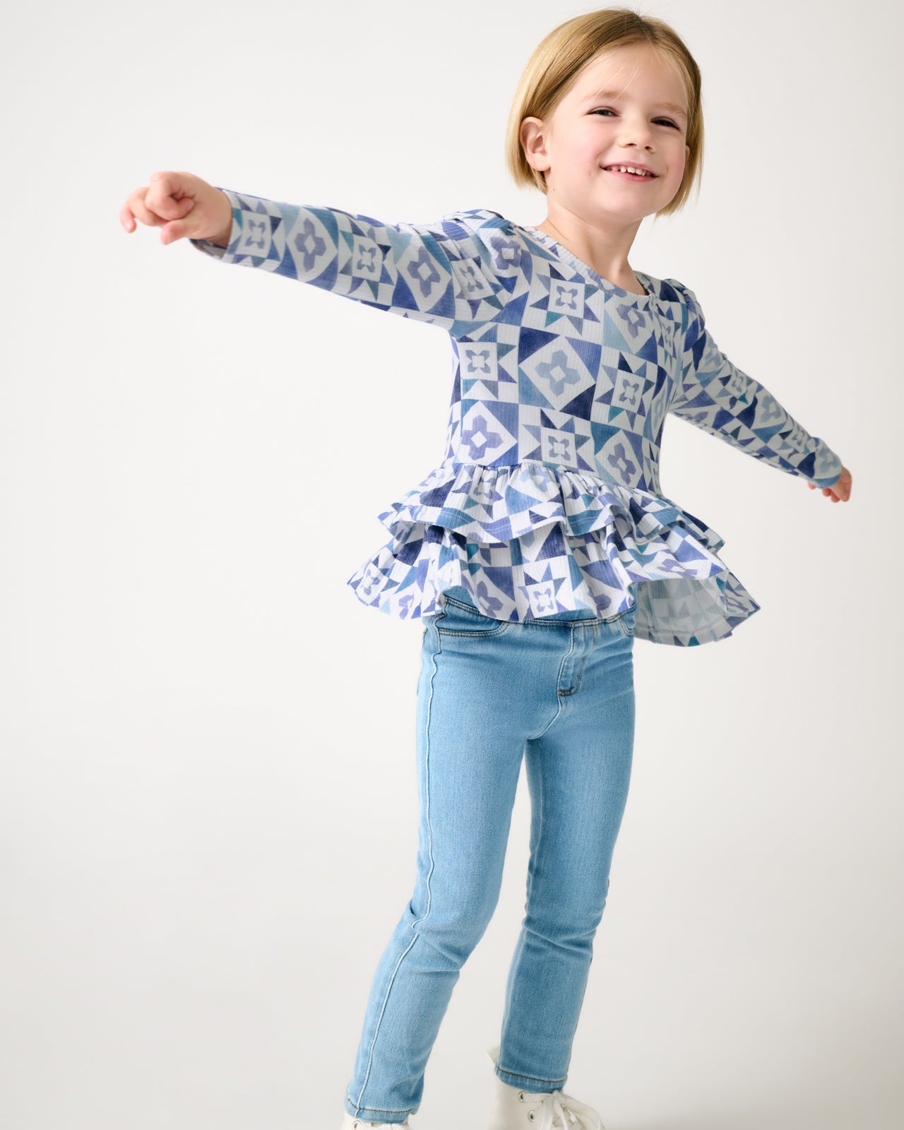 Girl wearing the Patchwork Indigo Ribbed Peplum Top with denim pants