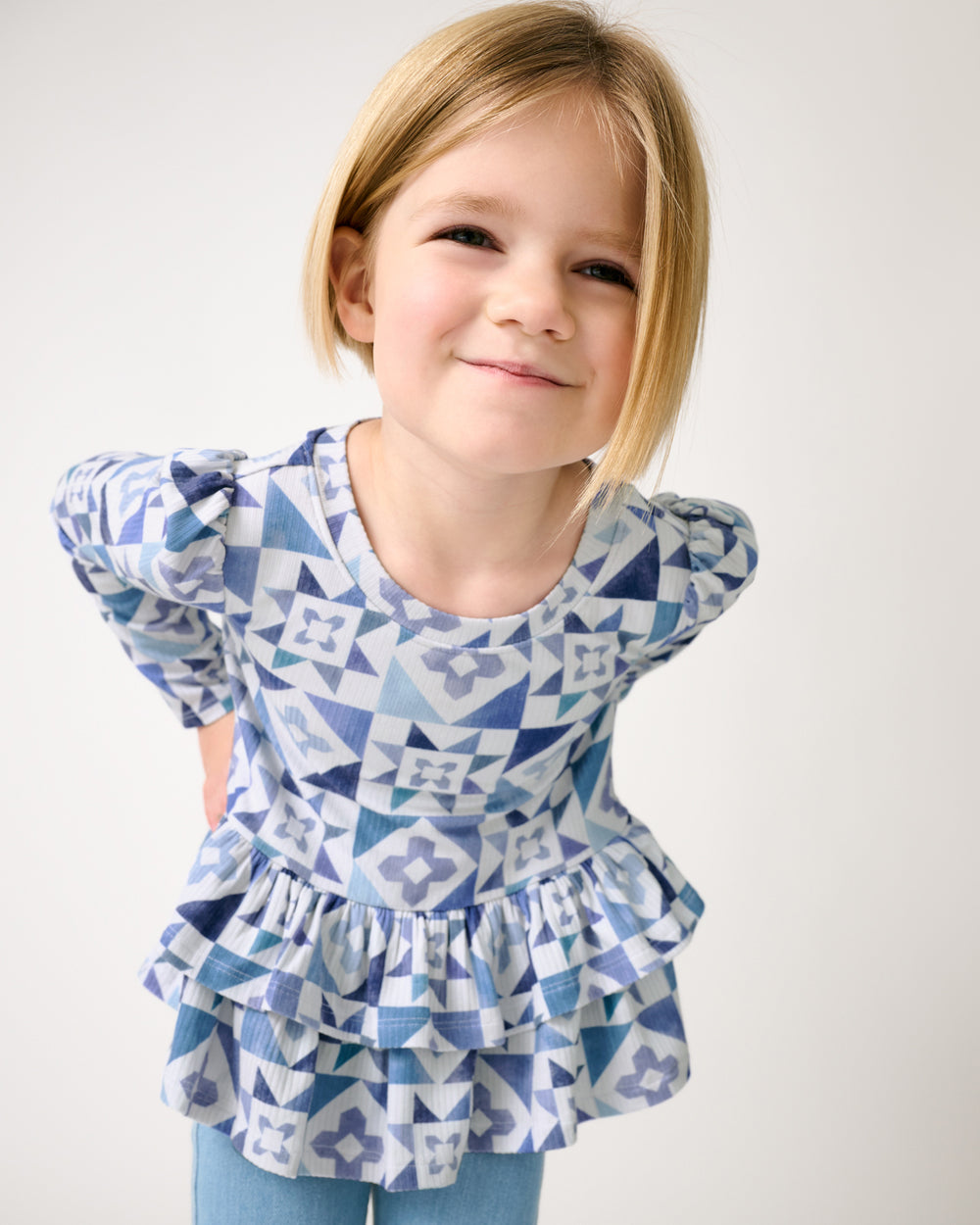 Close up of child wearing the Patchwork Indigo Ribbed Peplum Top