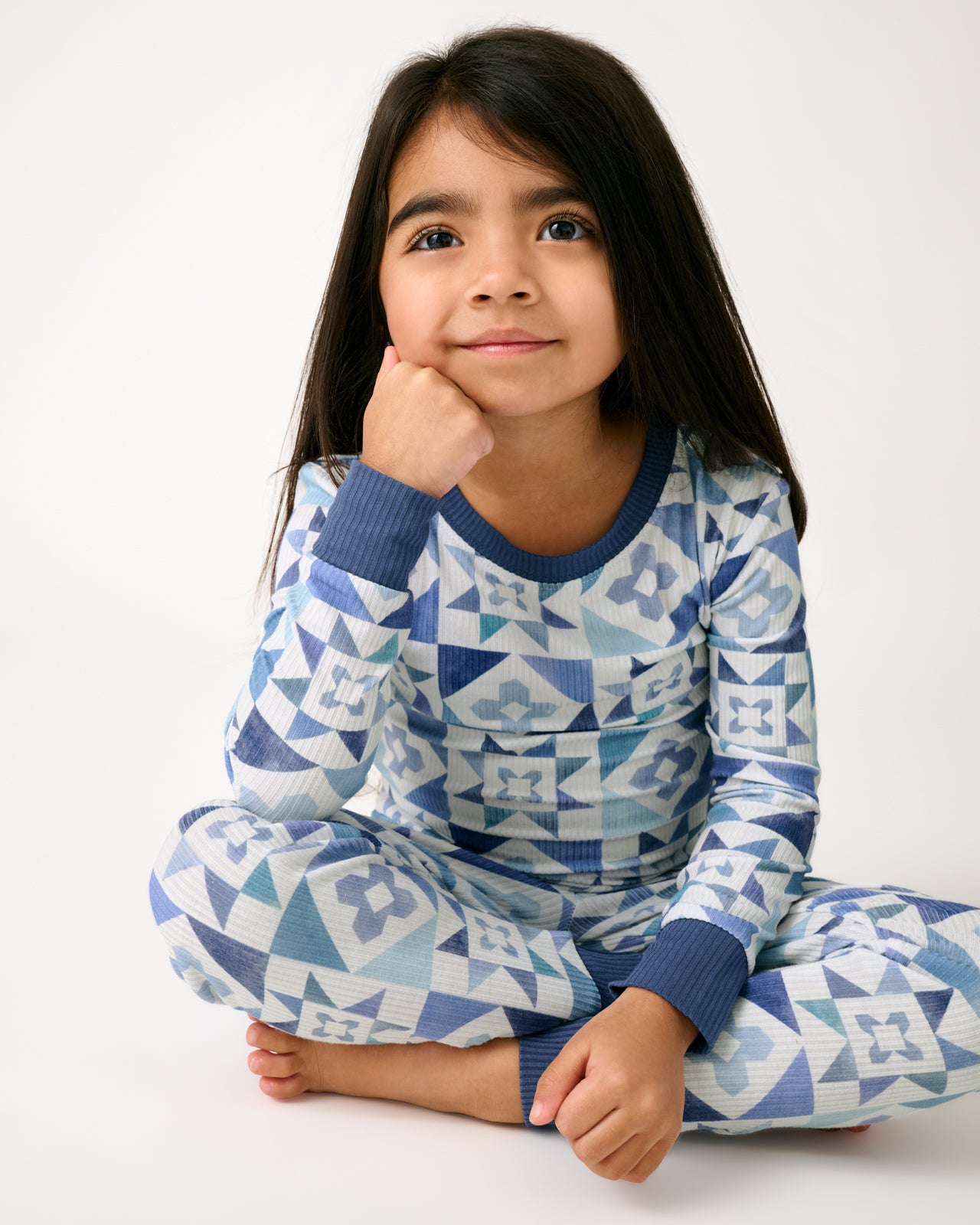 Sitting girl wearing the Patchwork Indigo Ribbed Two-Piece Pajama Set
