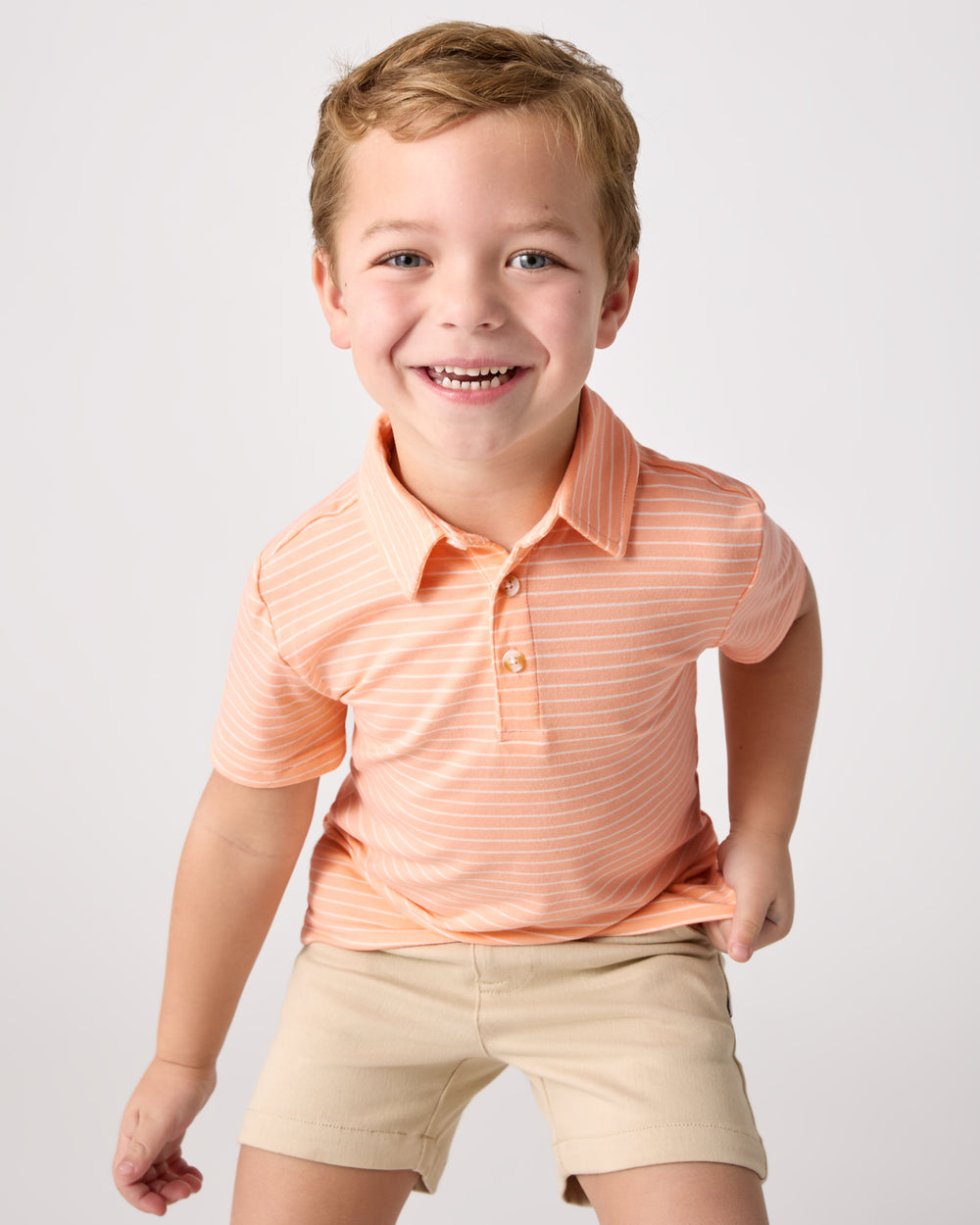 Boy wearing the Peachy Keen Stripe Polo Shirt with chino shorts
