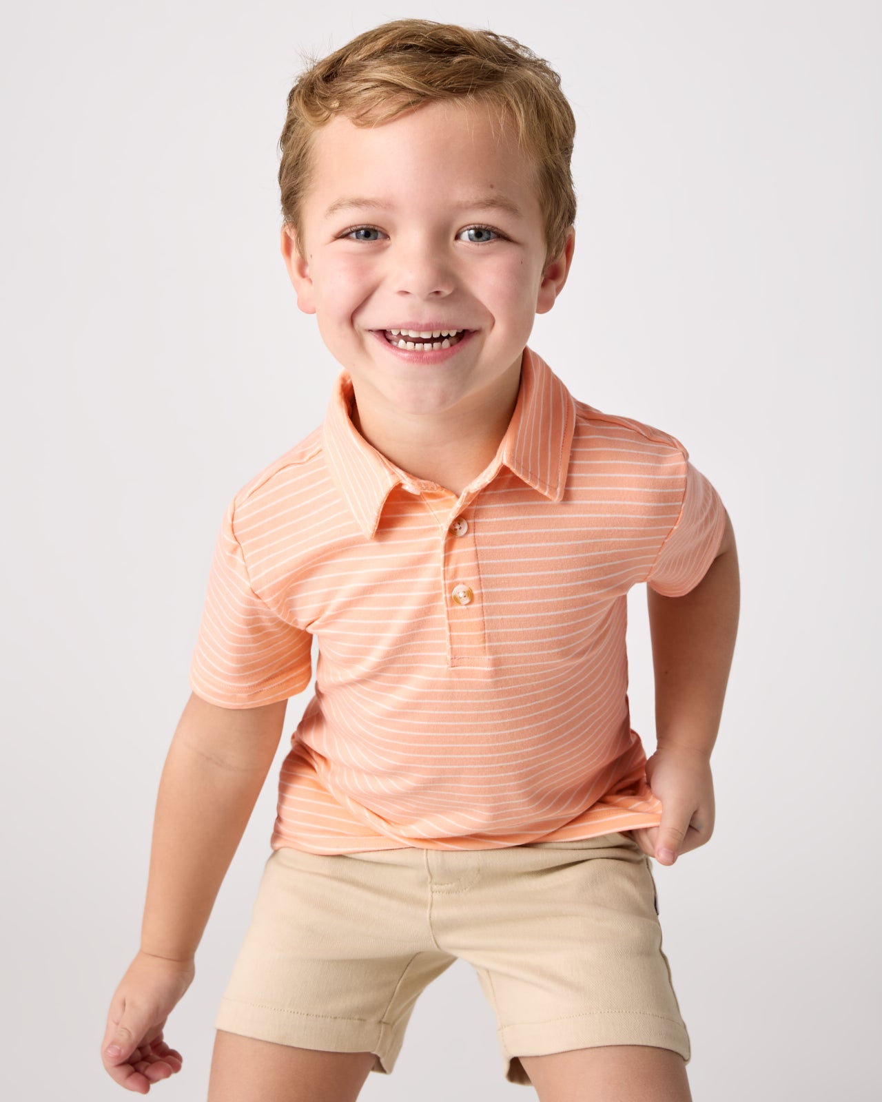 Boy wearing the Peachy Keen Stripe Polo Shirt with chino shorts