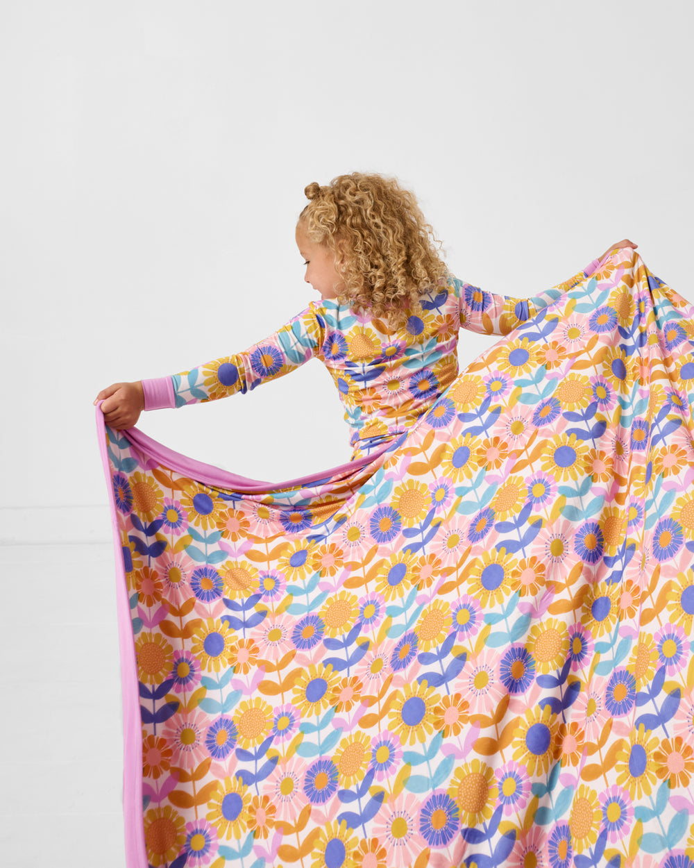 Back view of child holding the Petal Power Large Cloud Blanket®