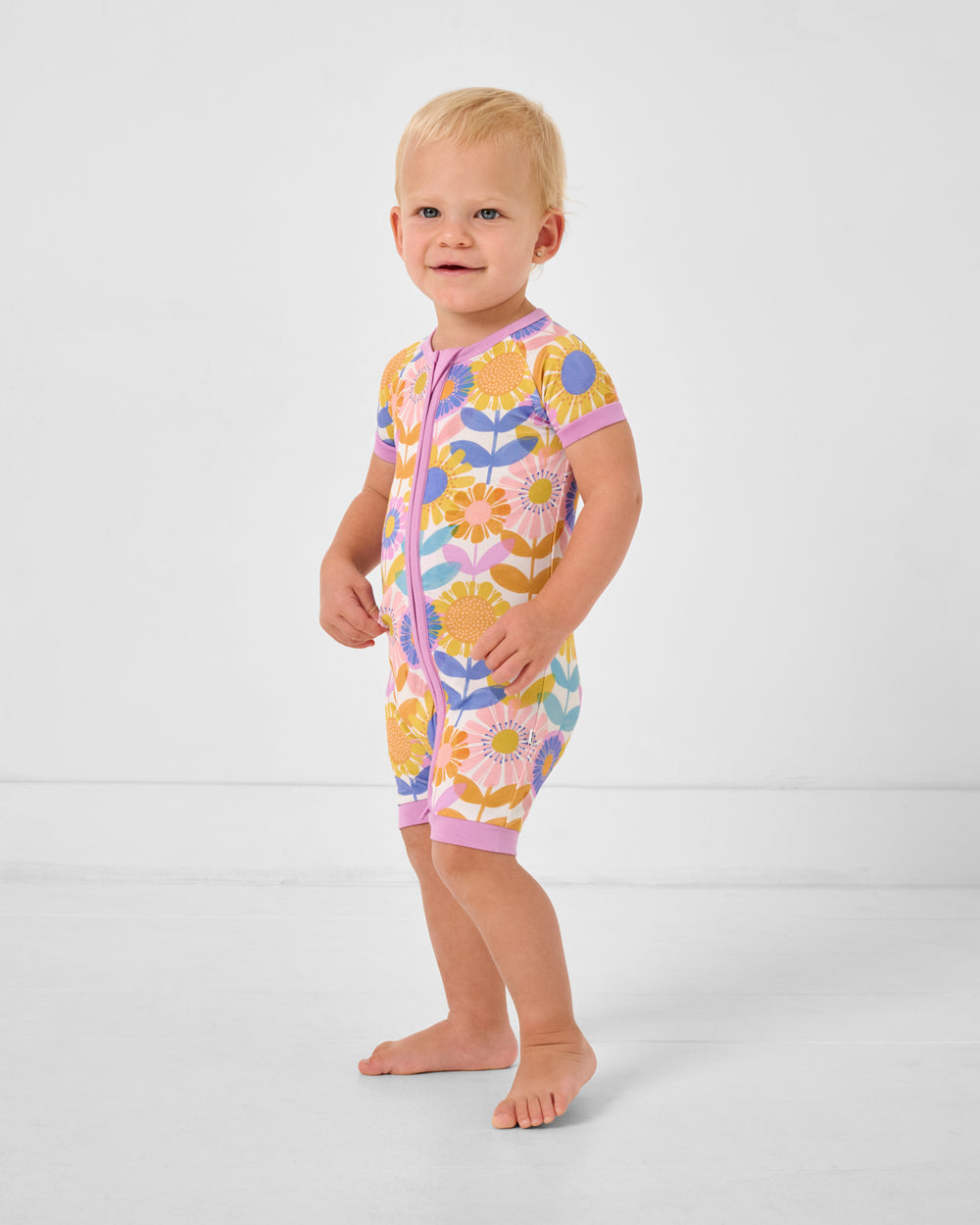 Standing toddler wearing the Petal Power Shorty Zippy