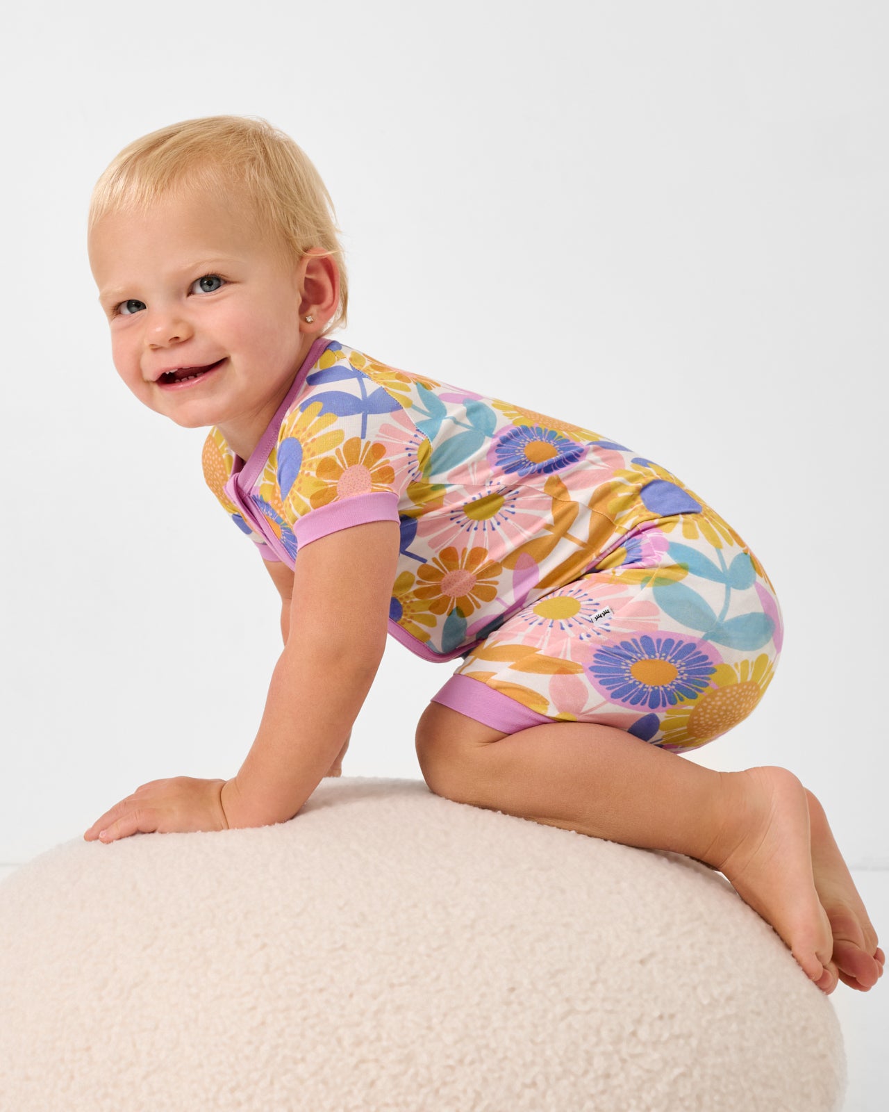 Close up of crawling baby wearing the Petal Power Shorty Zippy