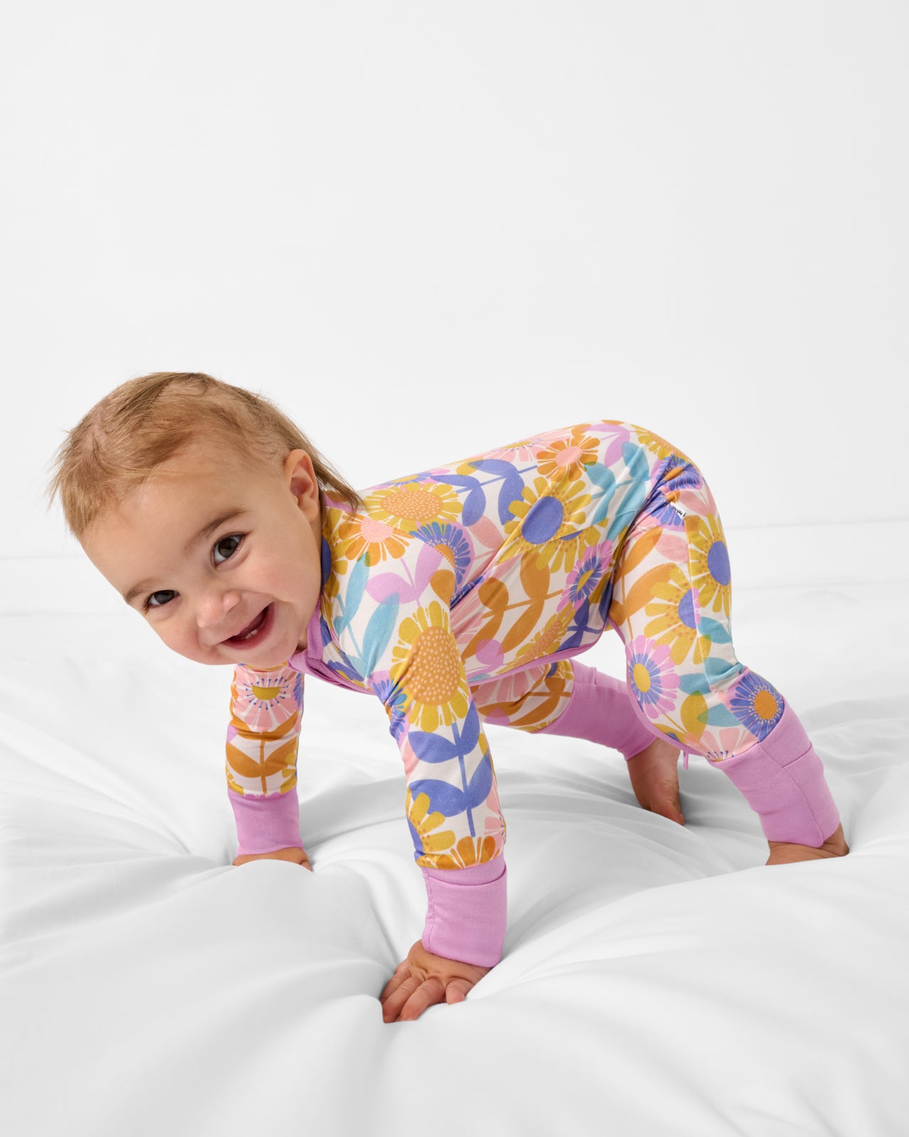 Crawling baby wearing the Petal Power Bamboo Zipper Pajamas