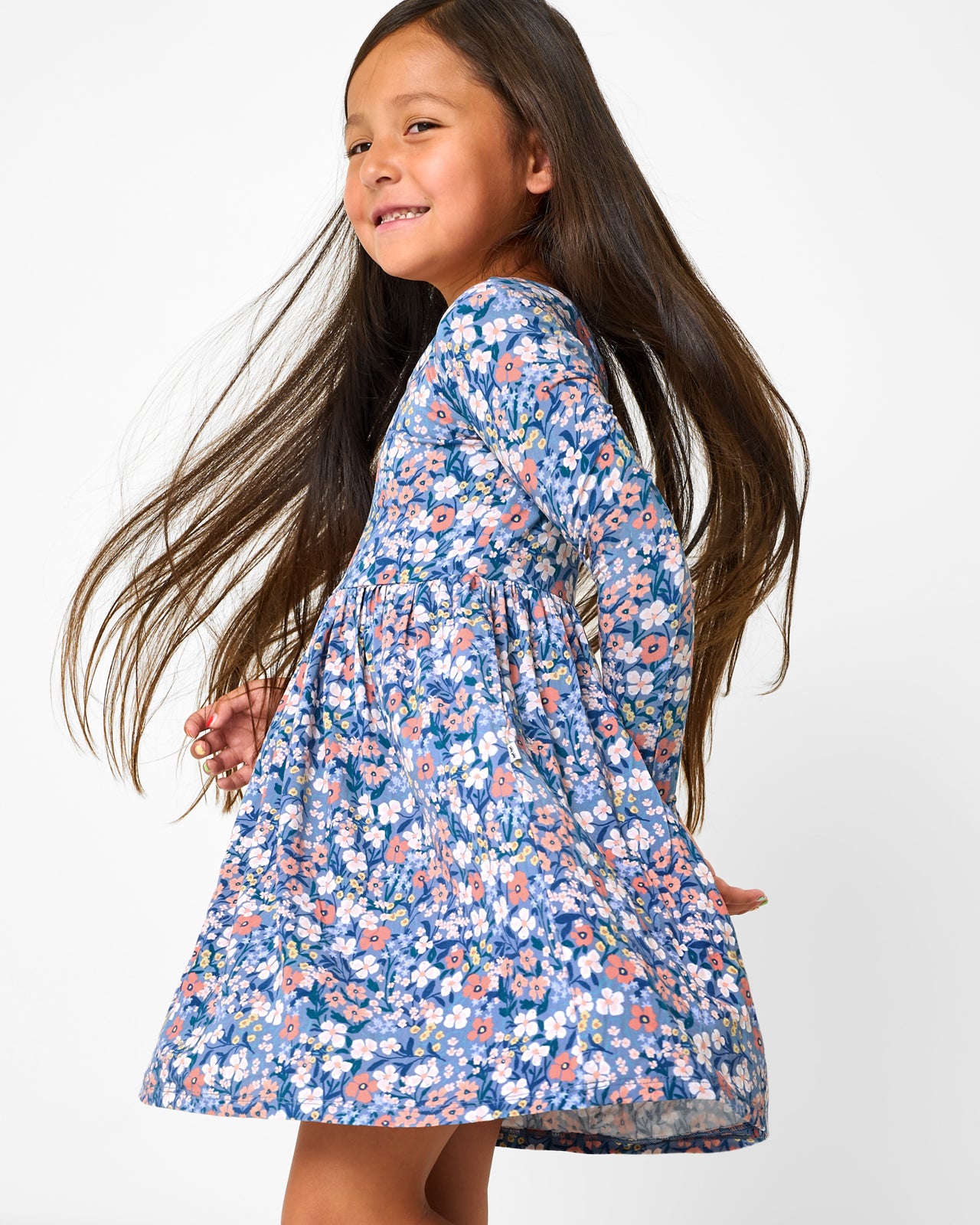 Twirling girl wearing the Petite Petals Bow Back Skater Dress