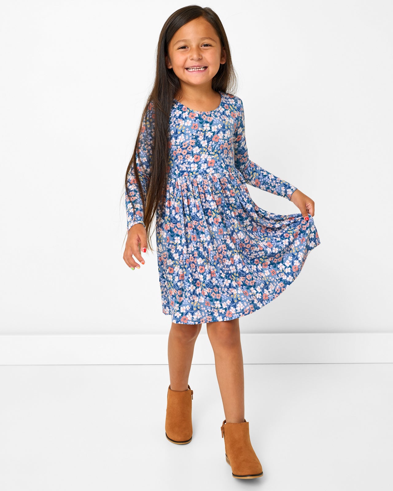 Girl wearing the Petite Petals Bow Back Skater Dress holding out the skirt