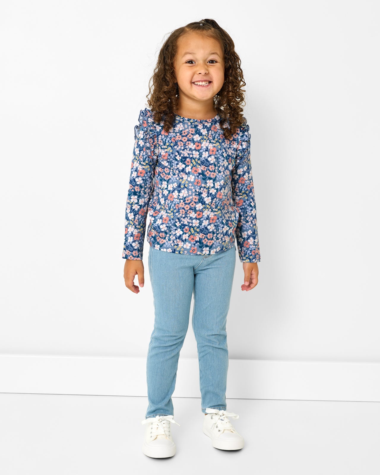 Girl wearing the Petite Petals Flutter Tee with denim pants