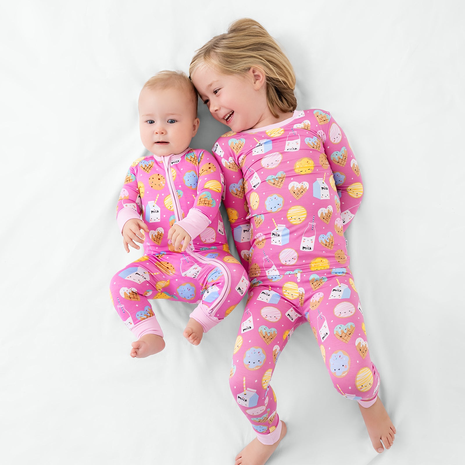 Aerial view of two siblings wearing matching Pink Cookies & Milk pajamas