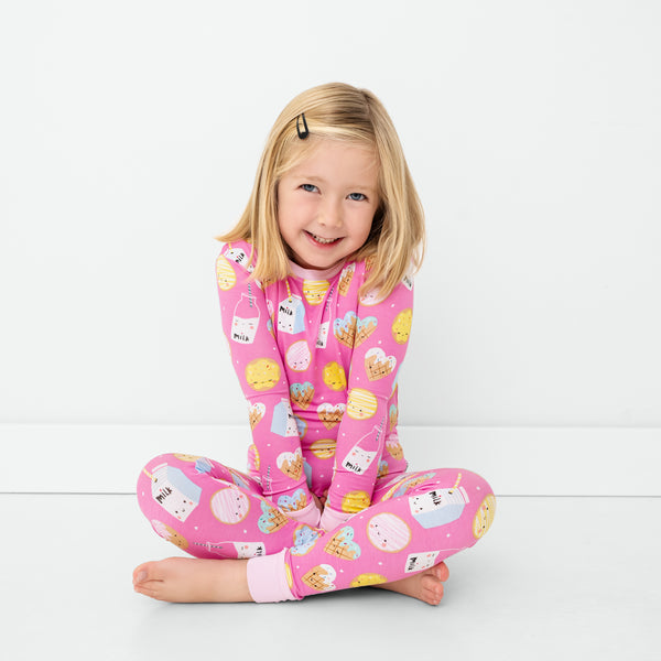 Sitting child wearing the Pink Cookies & Milk Two-Piece Pajama Set