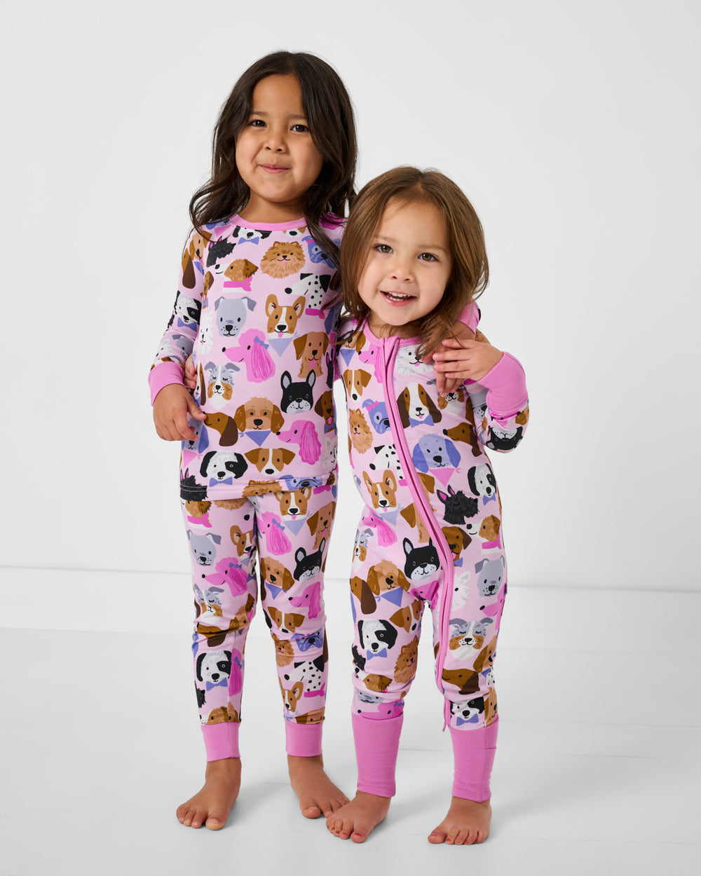 Two girls wearing matching Pink Puppy Parade bamboo pajamas