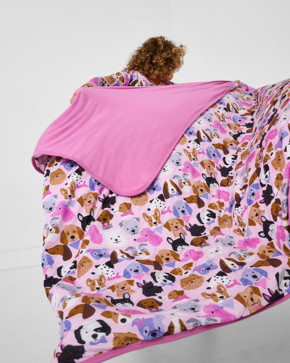 Child in motion wearing the Pink Puppy Parade Large Cloud Blanket®