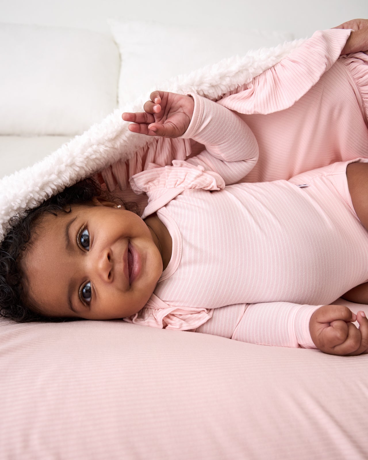 Baby cuddled in the Prima Pink Stripe Flutter Bodysuit
