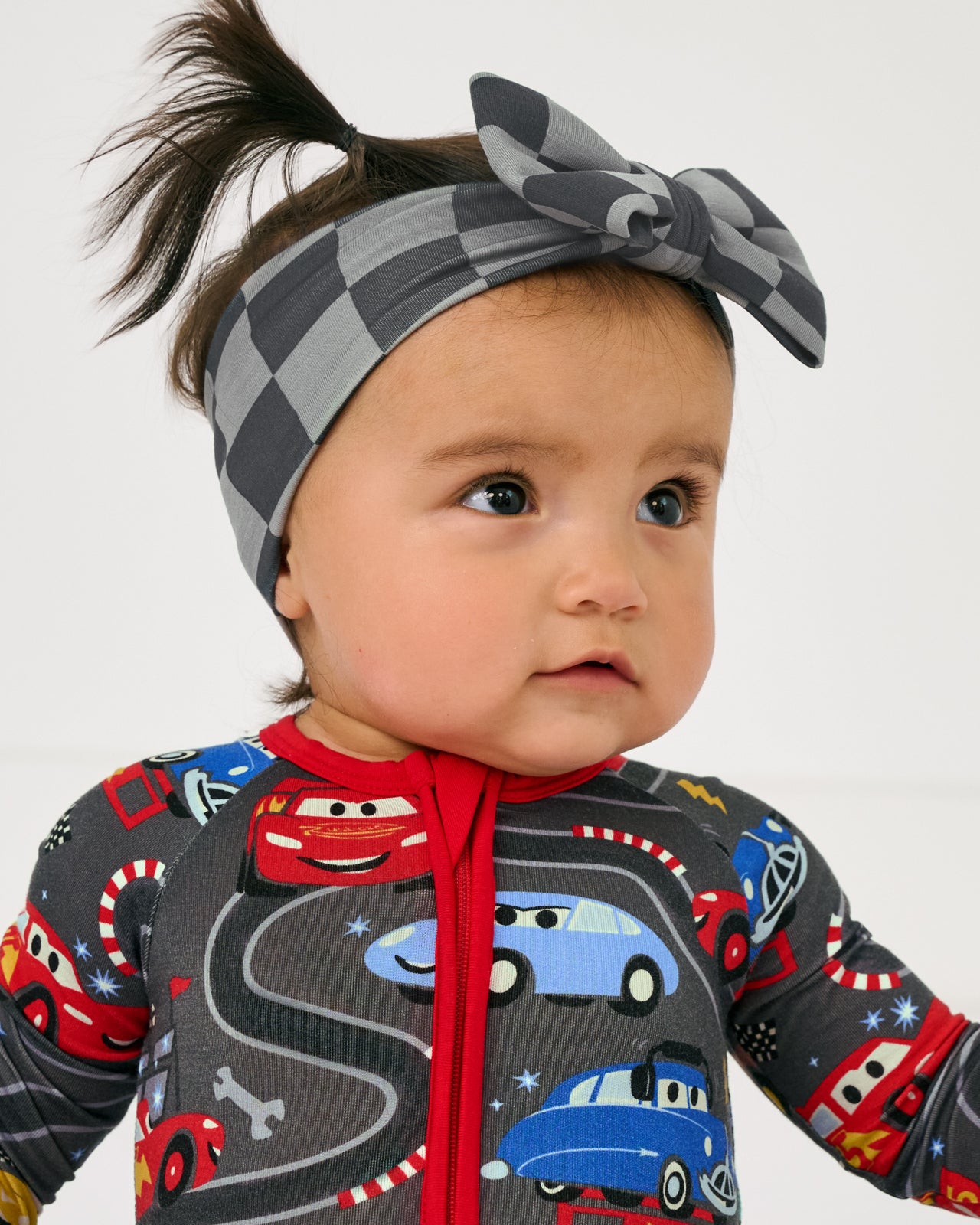 Close up of baby wearing a checkered print Luxe Bow Headband