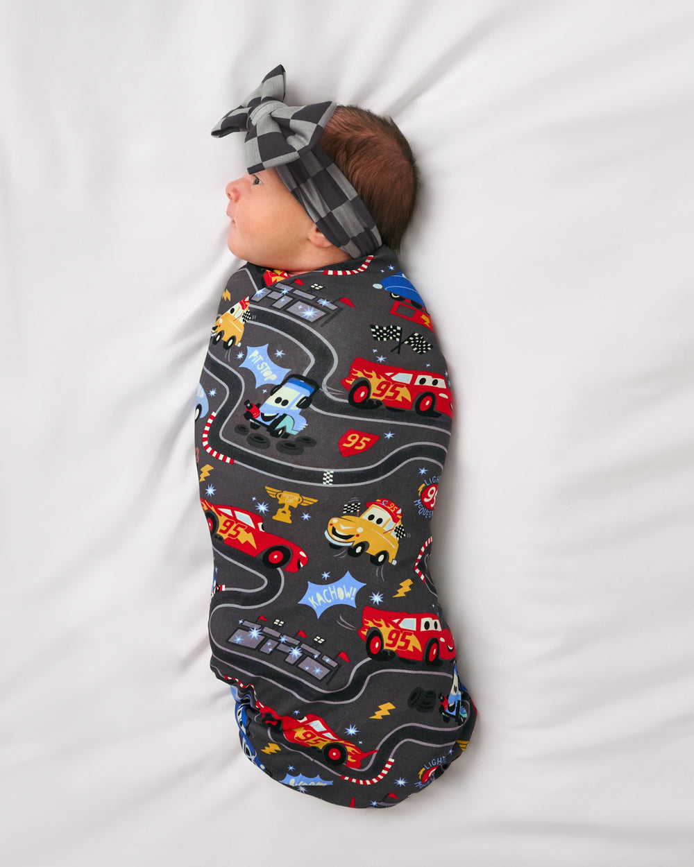 Alternate of baby wearing the Pixar Cars Piston Cup Swaddle & Luxe Bow Headband Set