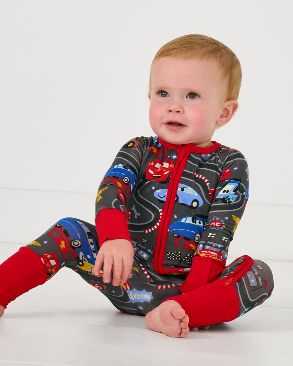 Sitting baby wearing the Disney & Pixar Piston Cup Zippy