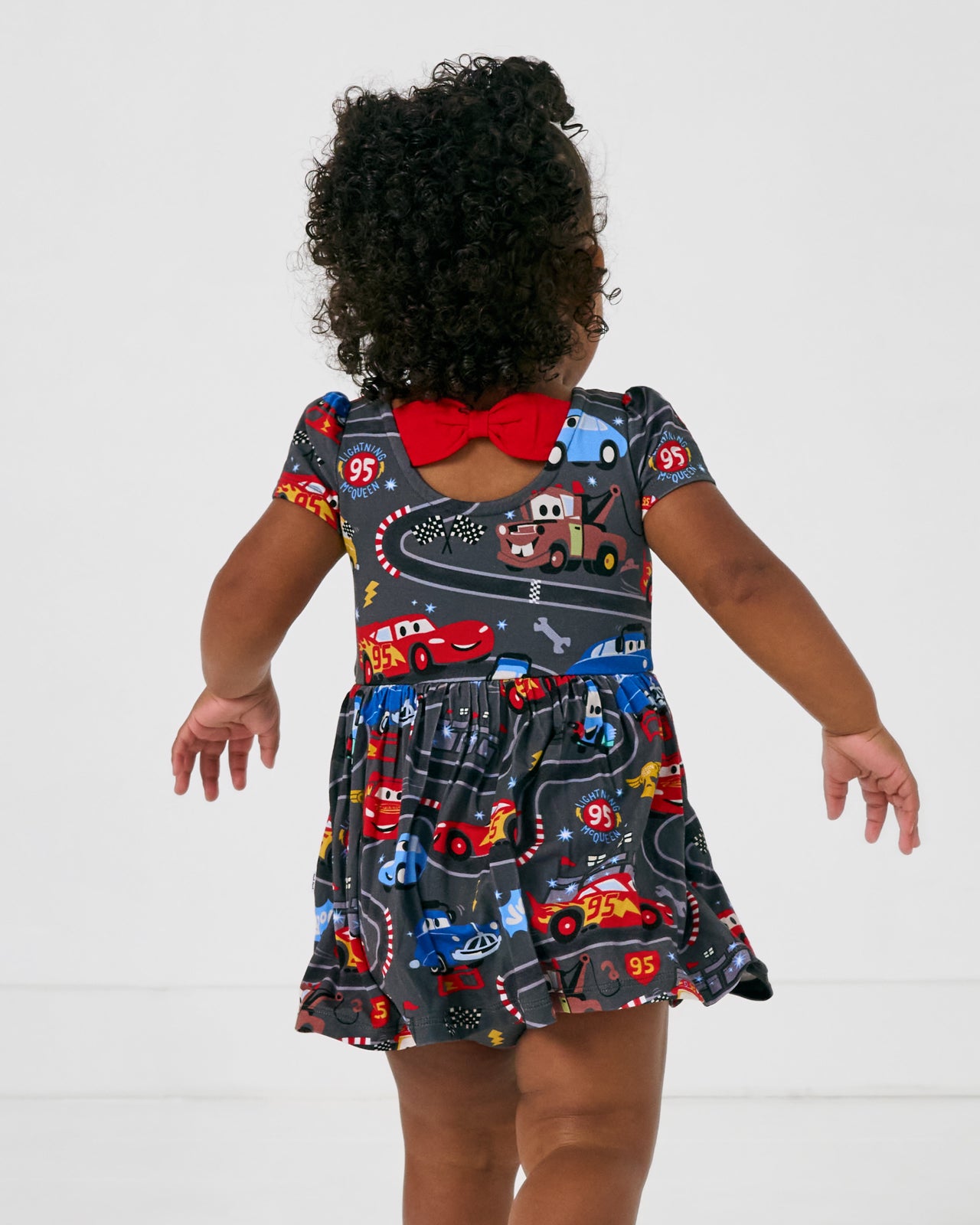 Back view of the Disney & Pixar Piston Cup Bow Back Skater Dress with Bodysuit