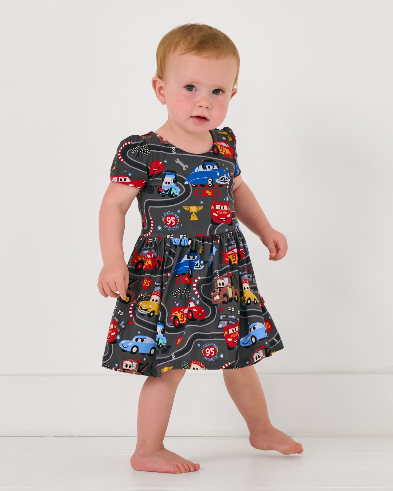 Alternate child wearing the Disney & Pixar Piston Cup Bow Back Skater Dress with Bodysuit