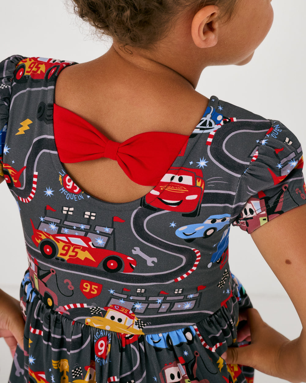 View of the back of the Disney & Pixar Piston Cup Bow Back Skater Dress