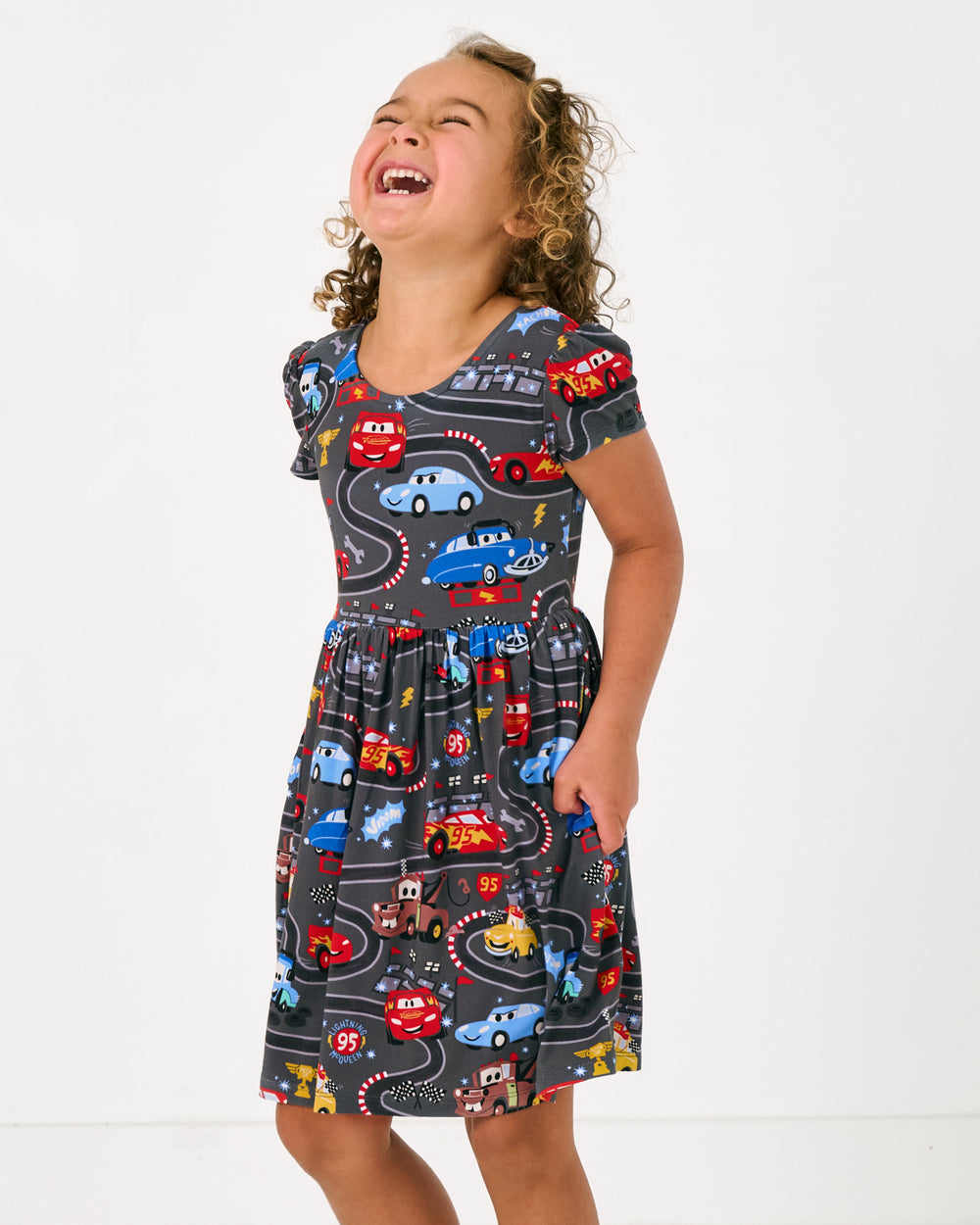 Alternate girl wearing the Disney & Pixar Piston Cup Bow Back Skater Dress