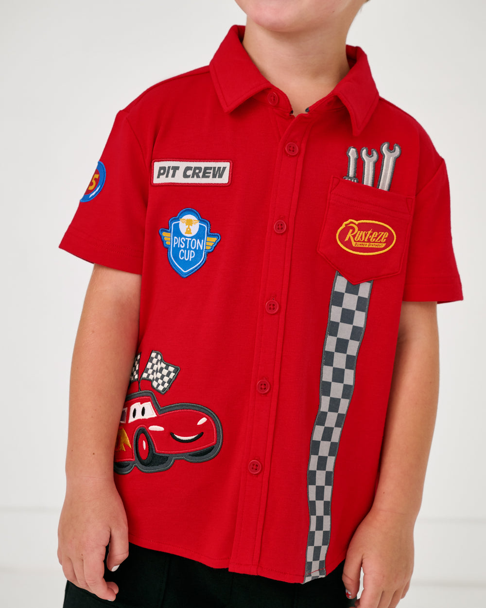Close up of boy wearing the Disney & Pixar Piston Cup Button Down Polo