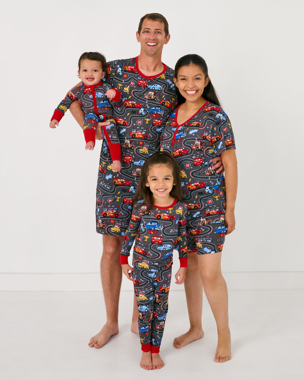 Family of four wearing matching Disney & Pixar Piston Cup pajamas