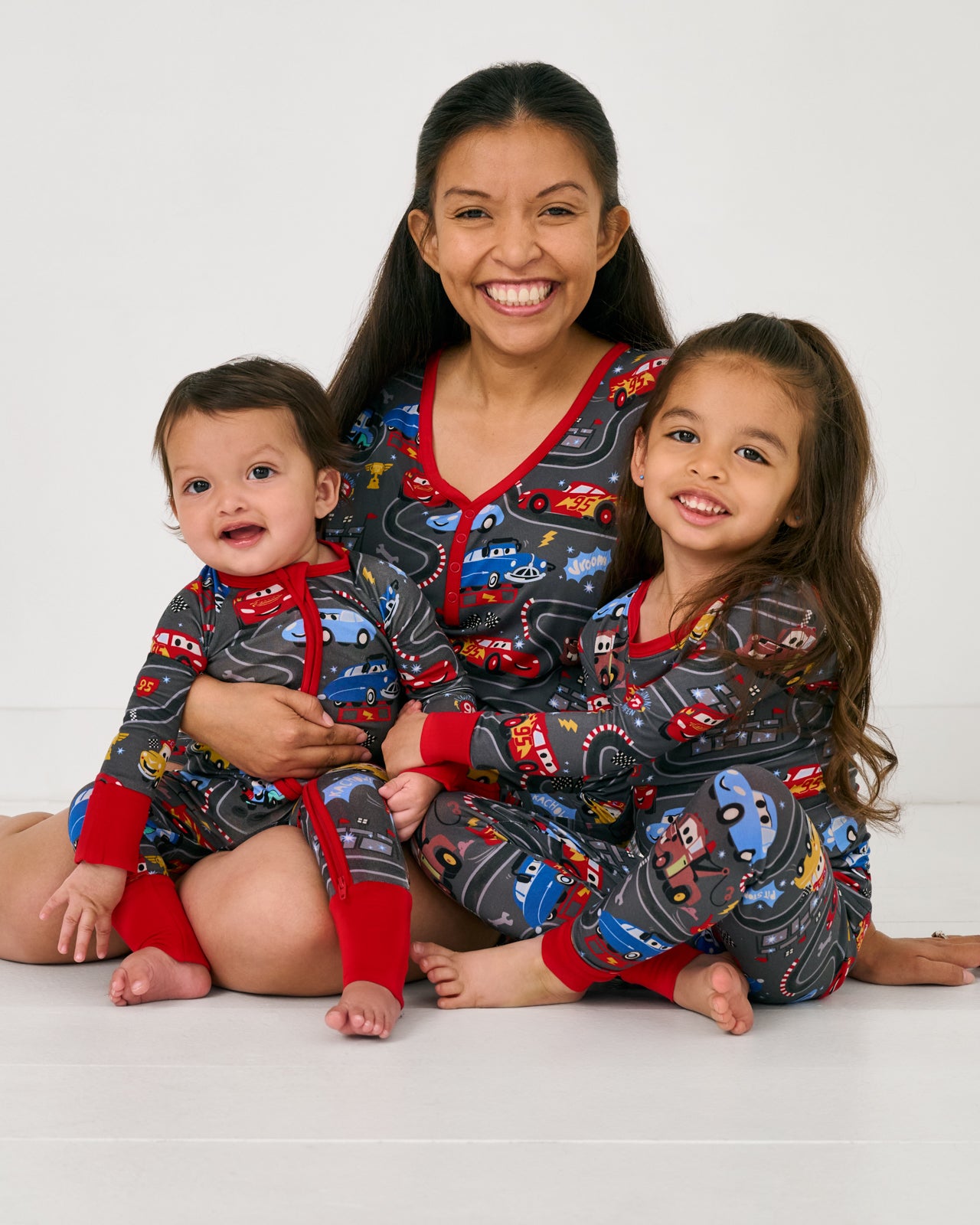 Mother and two children wearing matching Disney & Pixar Piston Cup bamboo pjs