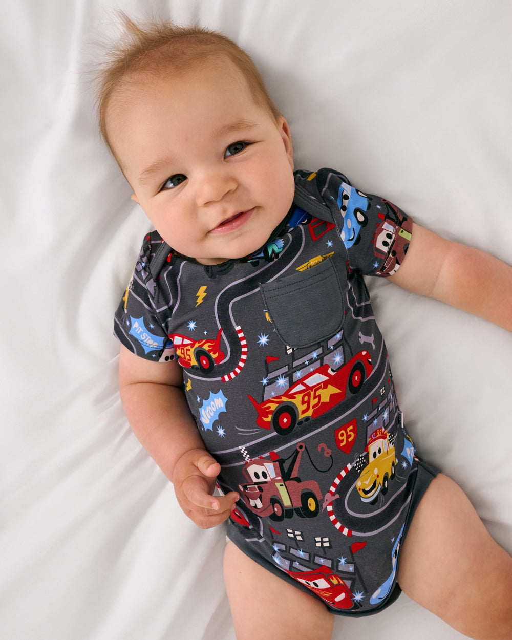 Aerial view of baby wearing the Disney & Pixar Piston Cup Pocket Bodysuit