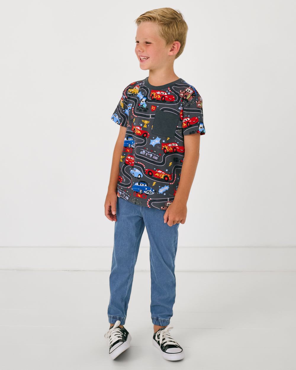 Boy wearing the Disney & Pixar Piston Cup Relaxed Pocket Tee with denim joggers