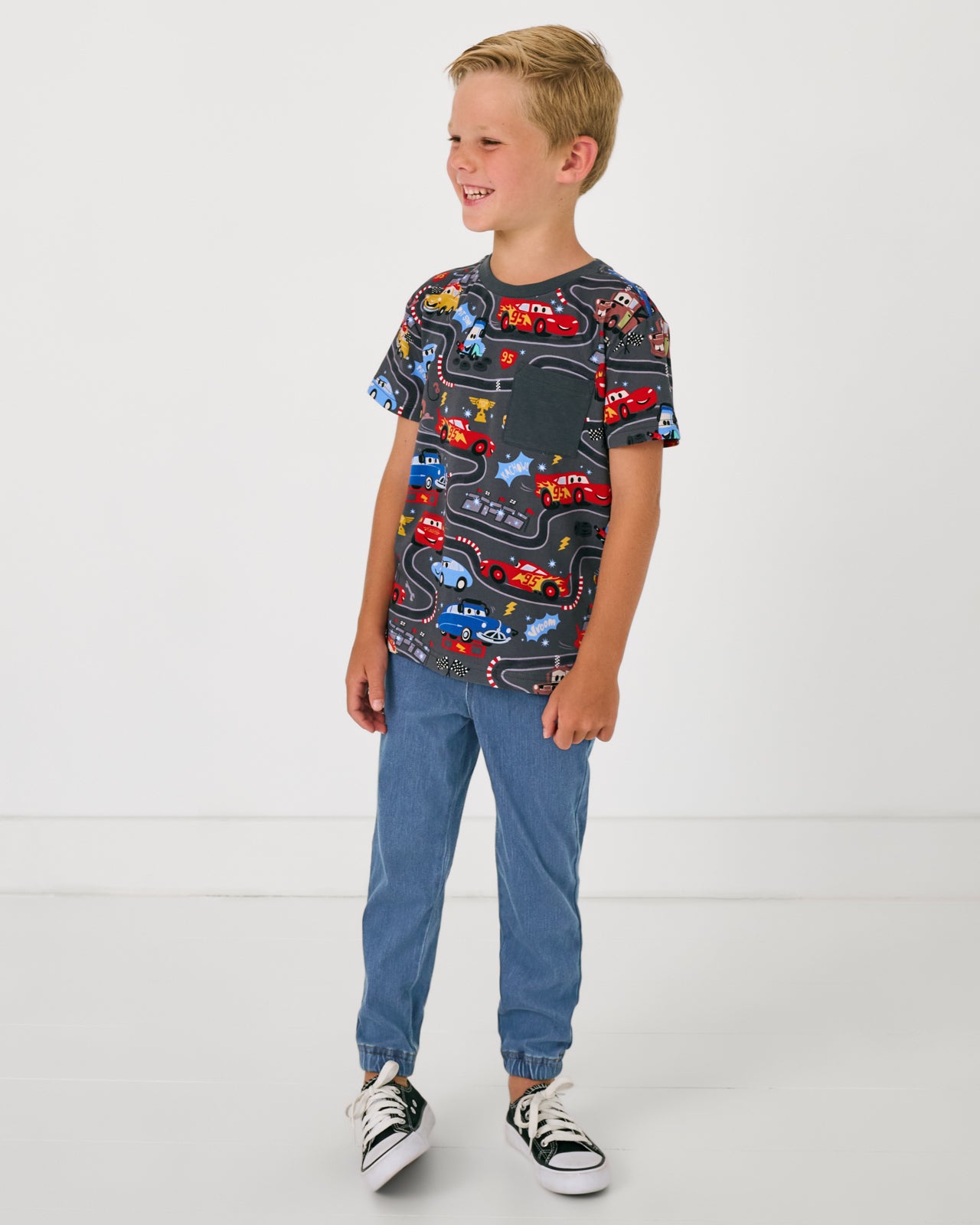 Boy wearing the Disney & Pixar Piston Cup Relaxed Pocket Tee with denim joggers