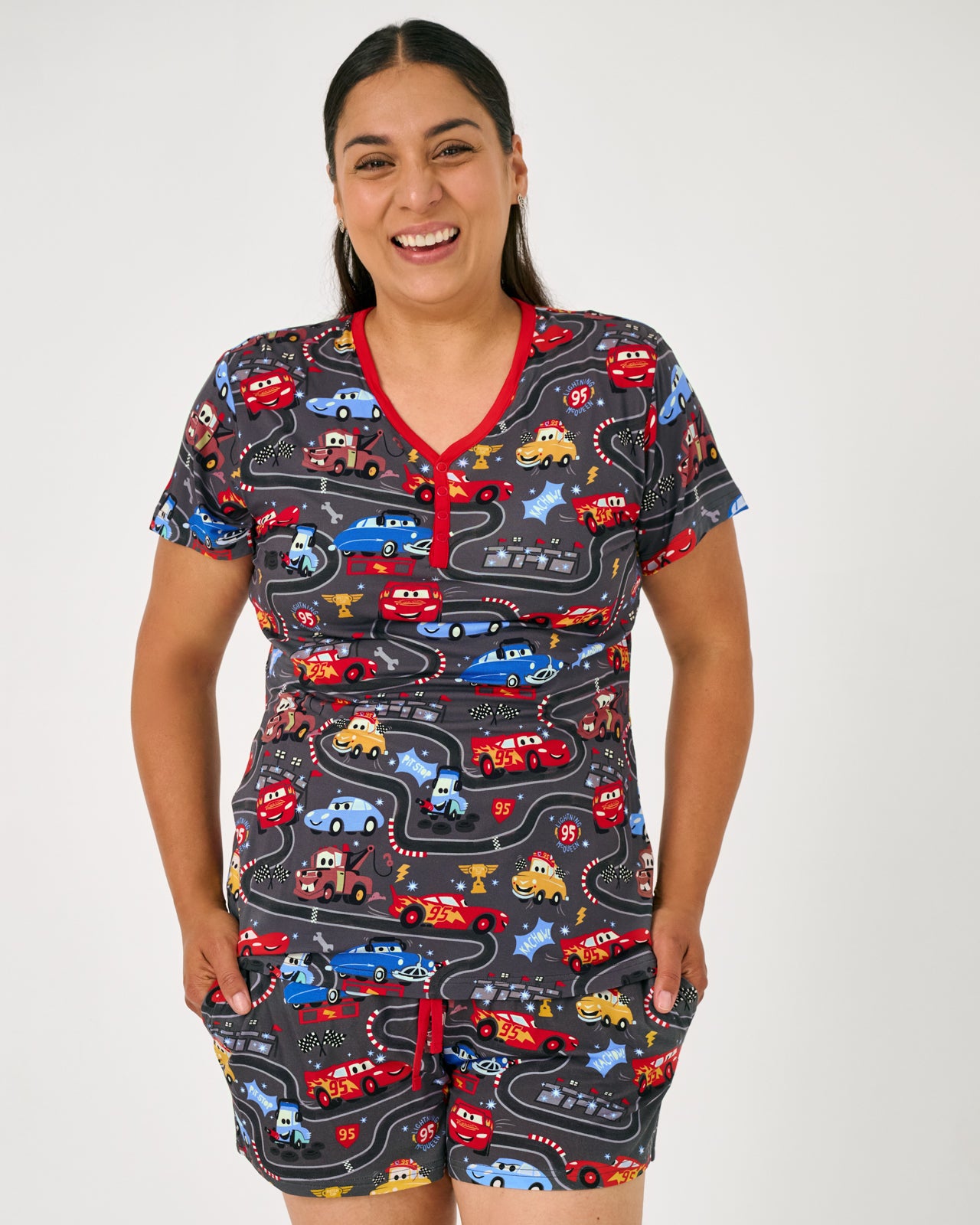 Standing woman wearing the Disney & Pixar Piston Cup Women's Short Sleeve Pajama Top