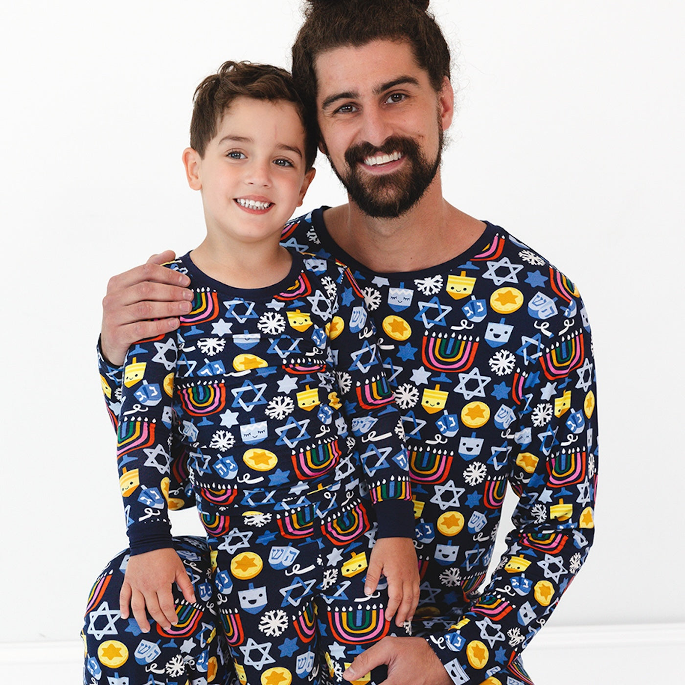 Father and son wearing matching Playful Dreidels pajamas