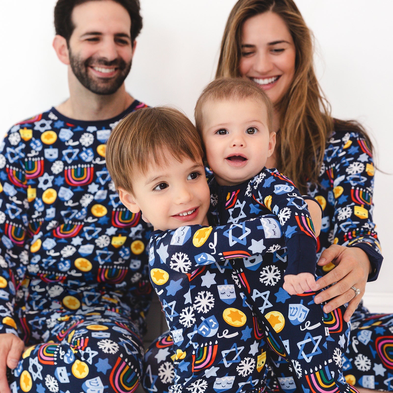 Family of four wearing matching Playful Dreidels pajamas