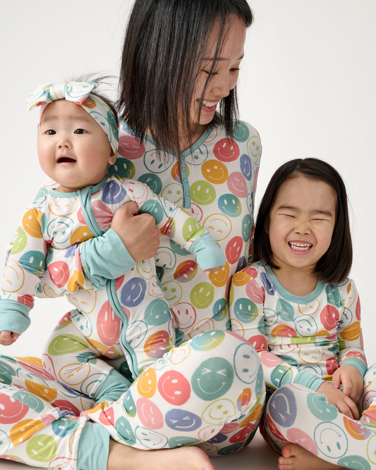 Family of three wearing matching Positive Vibes pajamas 