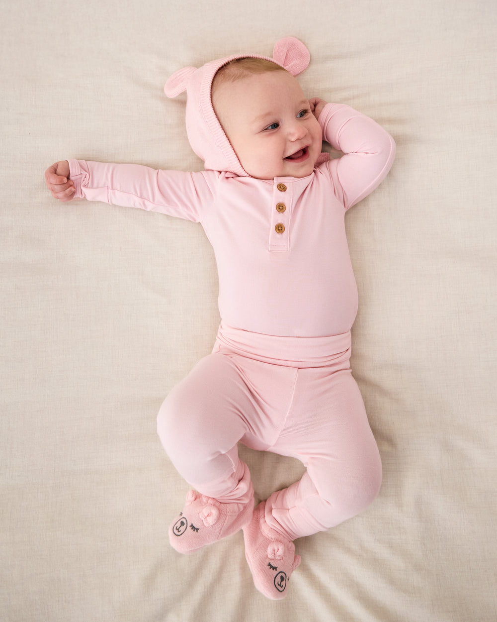 Newborn girl wearing the Prima Pink Henley Bodysuit with newborn leggings