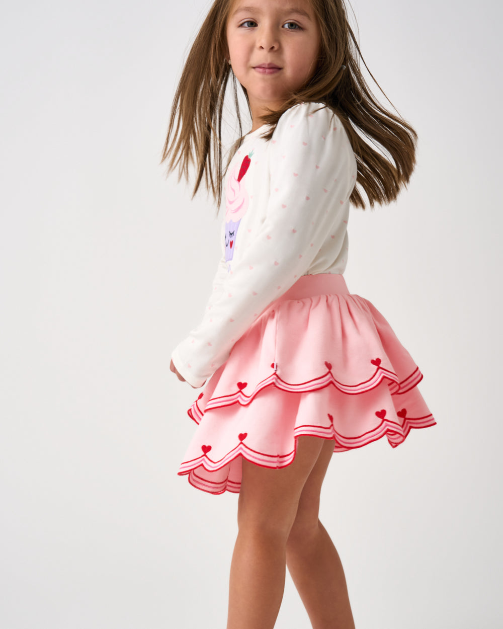 Close up of child wearing the Prima Pink Scalloped Skort