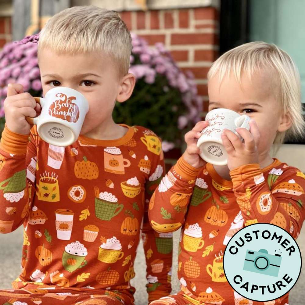 Customer Capture image of two children sitting together wearing matching Pumpkin Spice two piece pajama set