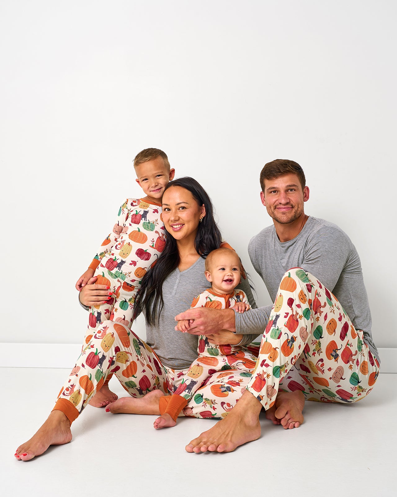 Family of four wearing matching Pumpkin Pals bamboo pajamas for fall