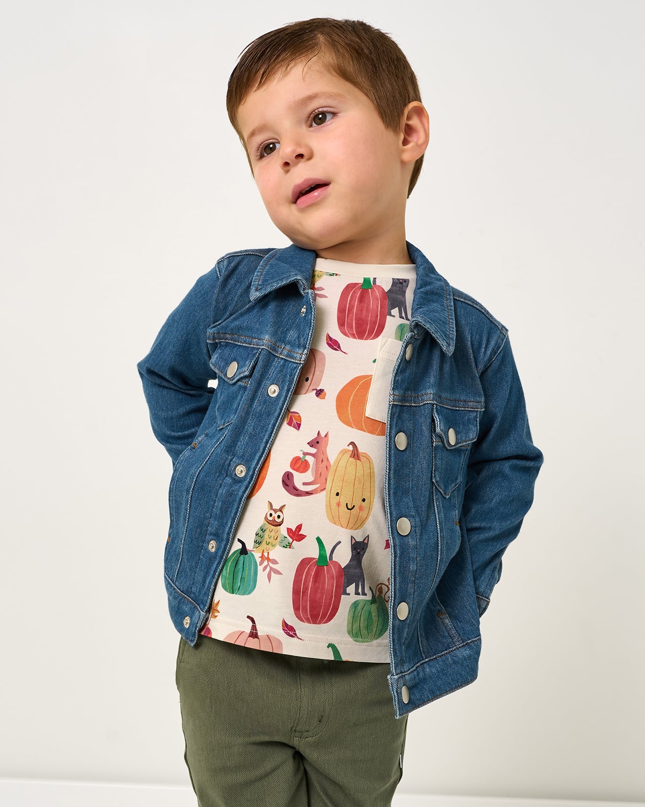 Boy wearing the Pumpkin Pals Relaxed Pocket Tee layered under a denim trucker jacket