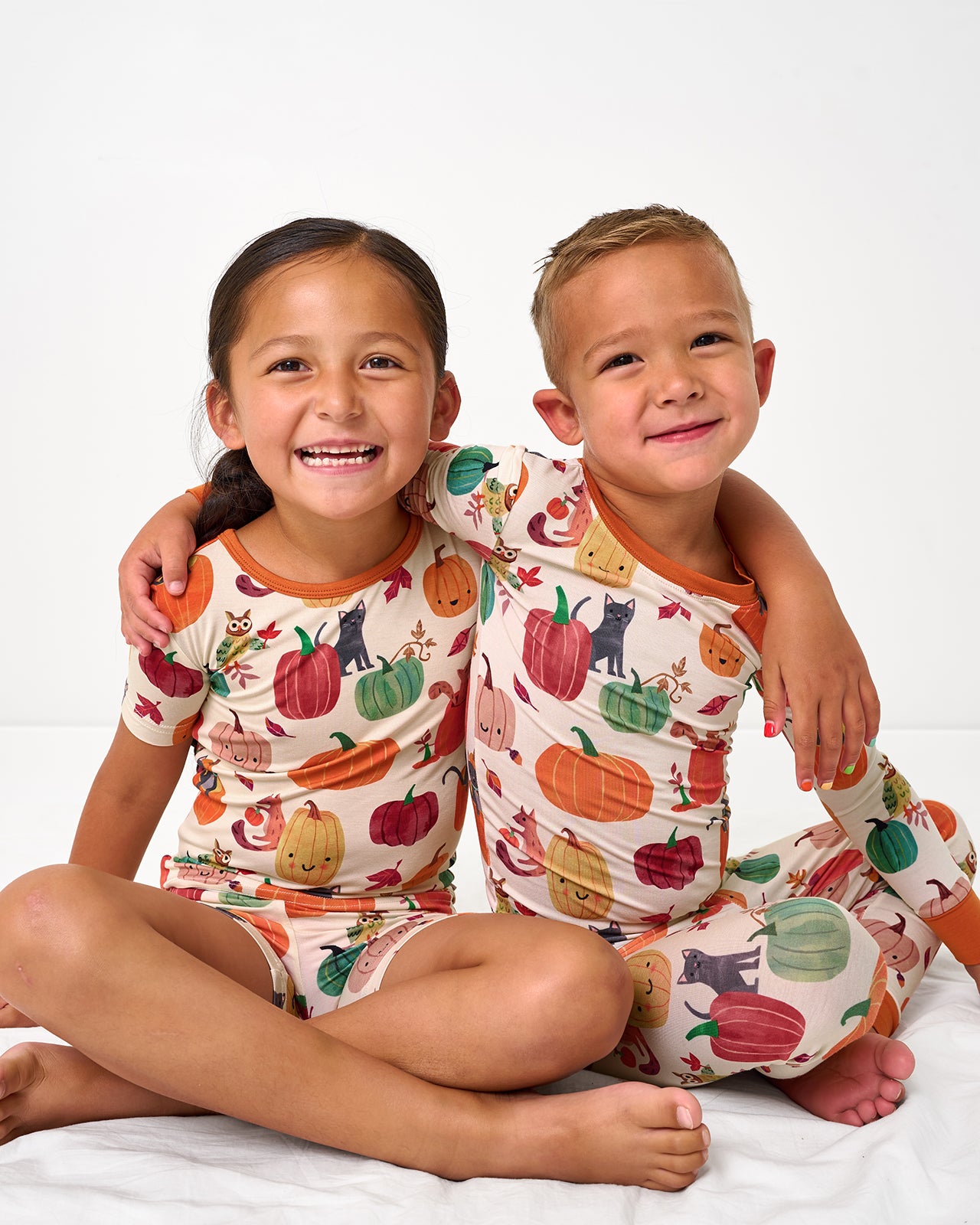 Two kids wearing matching Pumpkin Pals Two-Piece bamboo pj sets
