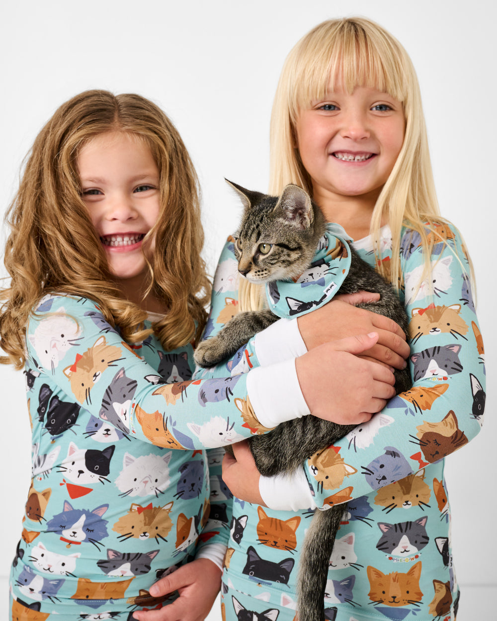 Two girls holding a cat wearing the Purrfect Pals Pet Bandana 
