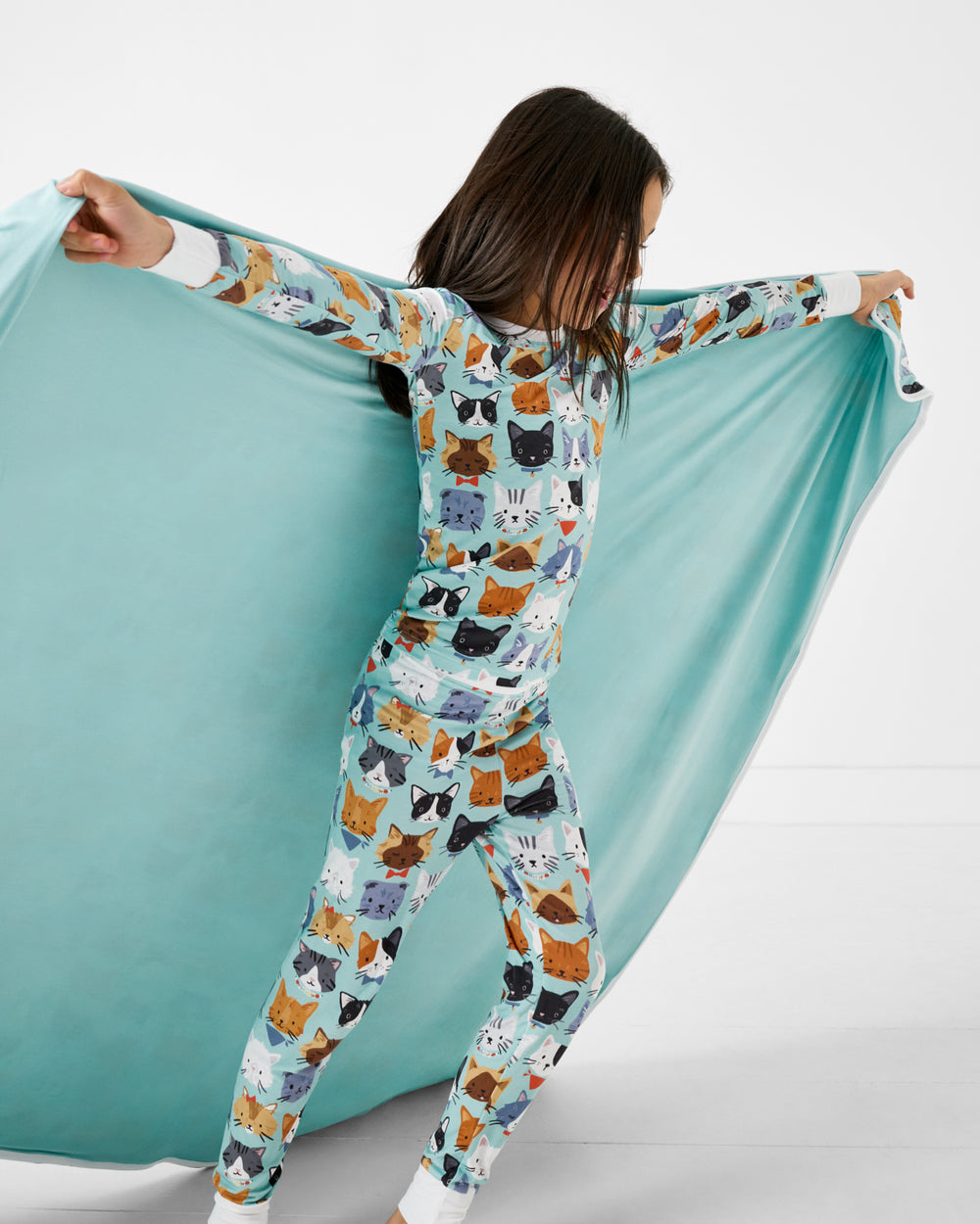 Girl holding up the Purrfect Pals Large Cloud Blanket® showing the solid blue side